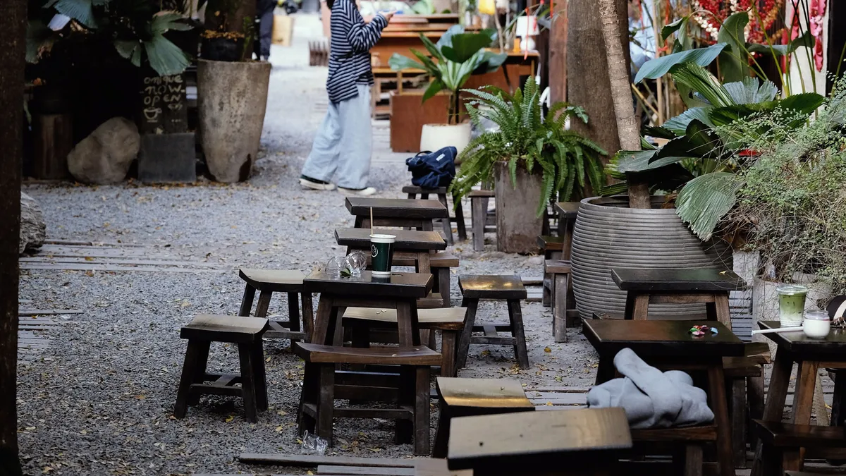 A leafy outdoor cafe with wooden seating in Chiang Mai, Thailand